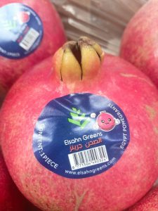 A pomegranate carrying the Elsahn Greens fruit label