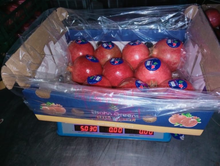 A packed pomegranate carton being weighed
