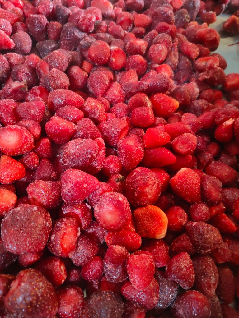 Close view of IQF whole strawberries with frost on the fruit